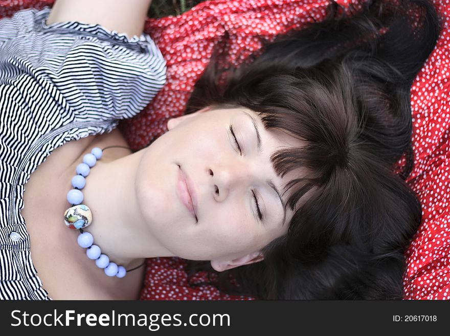 Attractive girl, lying on a grass and smiling. Close up. Attractive girl, lying on a grass and smiling. Close up.