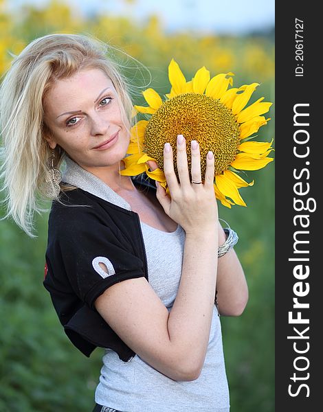 Beauty woman and sunflowers on field