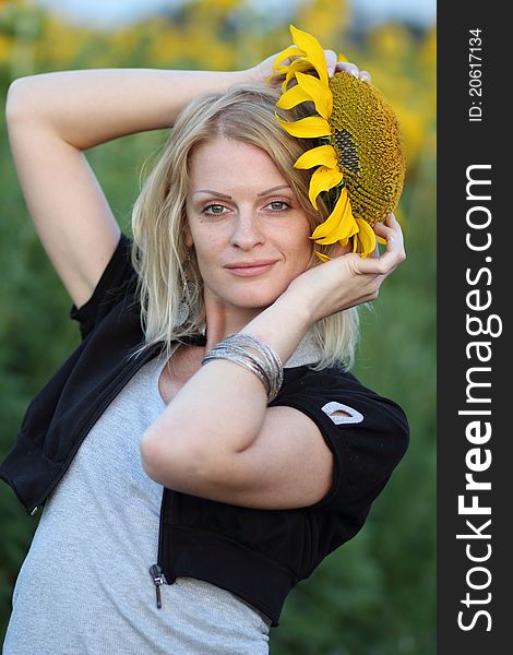 Beauty woman and sunflowers on field