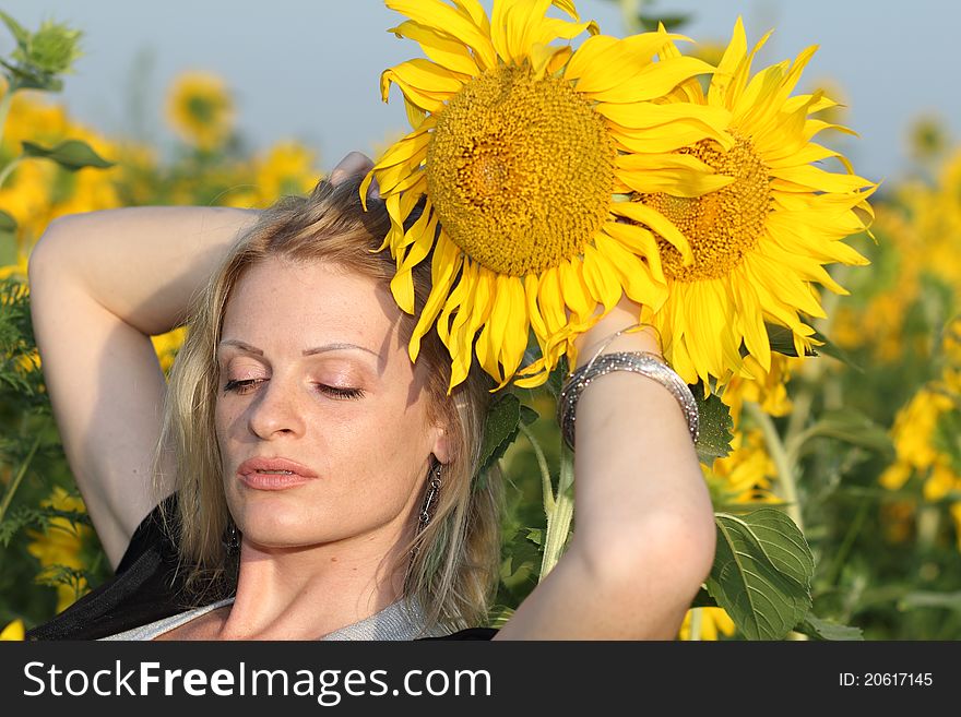 Beauty woman and sunflowers on field