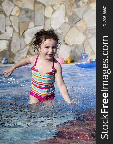 Cute small girl is laughing and playing in the swimming pool. Cute small girl is laughing and playing in the swimming pool
