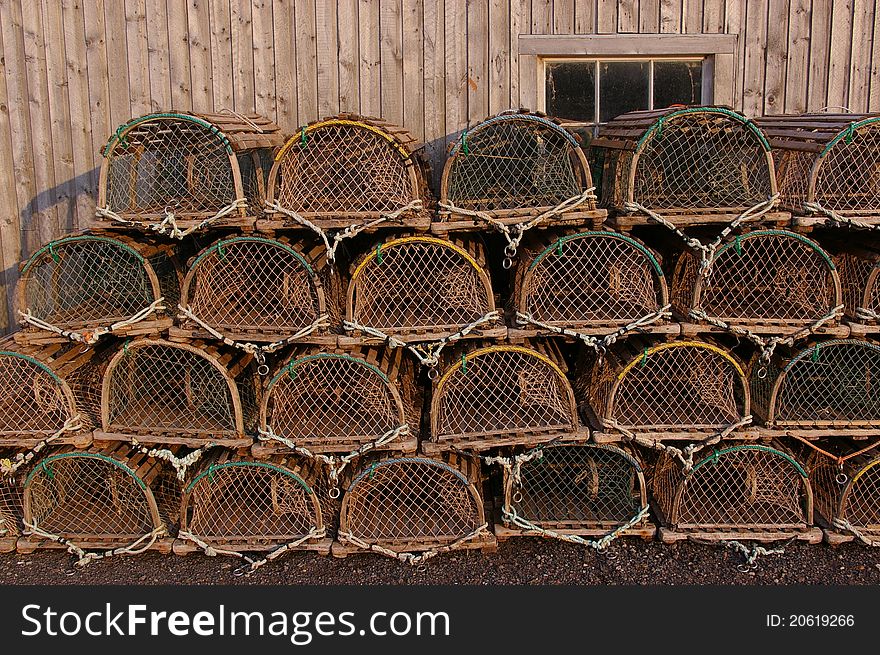 Lobster traps stacked beside a fish shed. Lobster traps stacked beside a fish shed