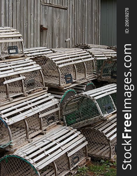 Lobster traps stacked beside a fish shed. Lobster traps stacked beside a fish shed