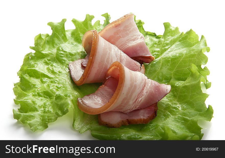 Some pieces of bacon on the green lettuce