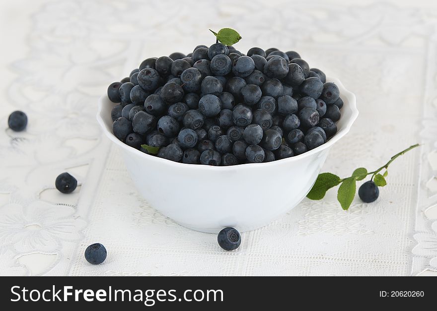 Bowl of bilberries on white background