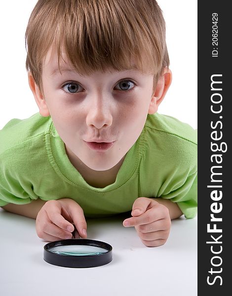 Boy with magnifying glass isolated on a white background