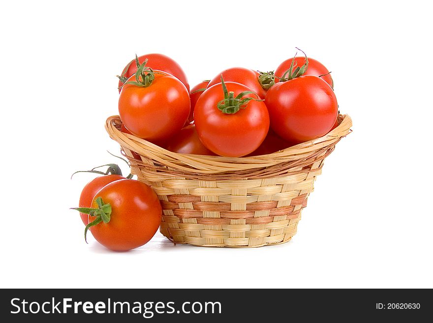 Ripe tomatoes in a wicker basket isolated on a white background