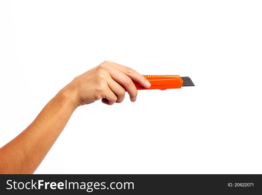 A female hand holding an orange craft knife on an isolated white background. A female hand holding an orange craft knife on an isolated white background