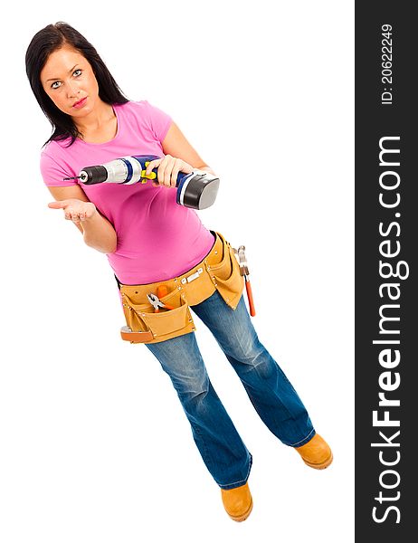 A young female wearing pink top blue jeans and tool belt holding an electric drill on isolated white background. A young female wearing pink top blue jeans and tool belt holding an electric drill on isolated white background