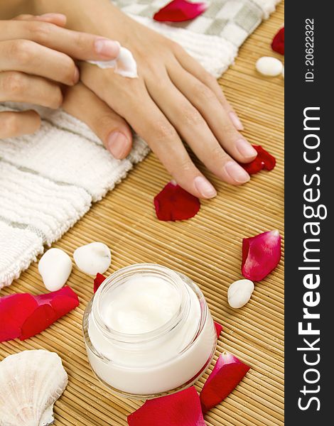 Close-up of girl lying on hand towel next to the cream, rose petals. Close-up of girl lying on hand towel next to the cream, rose petals