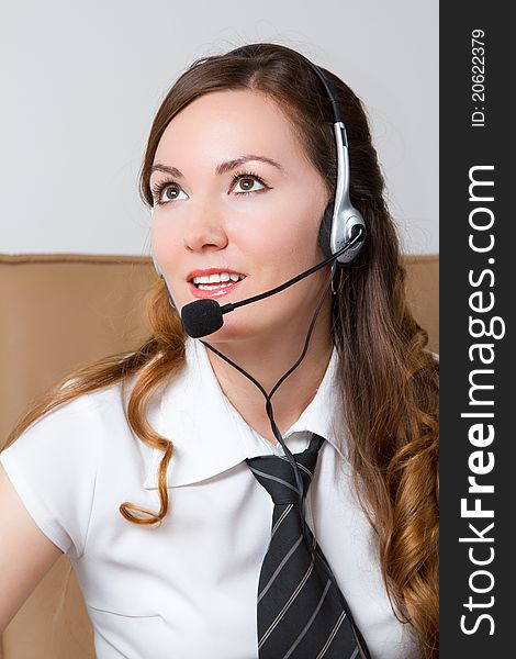 Business woman talking in a tie with headphones in the office. Business woman talking in a tie with headphones in the office