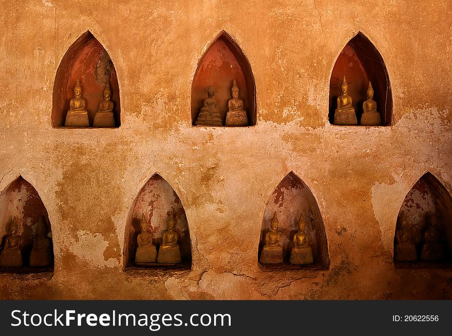 Seven small alcoves on the wall each with two small Buddha statues. Seven small alcoves on the wall each with two small Buddha statues