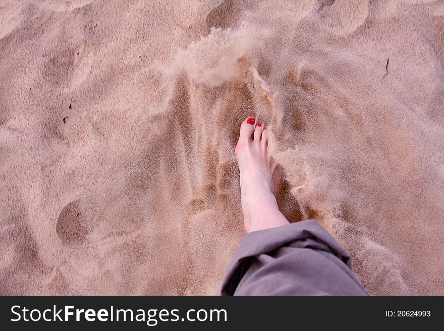 Woman s foot in soft sand