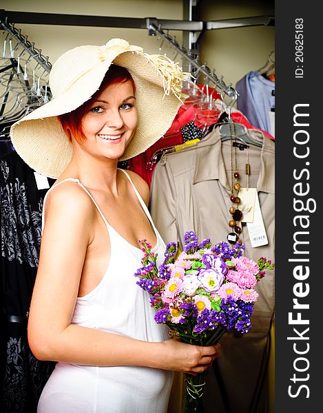 Portrait of a Young Woman with flowers. Standing in a Clothing Store