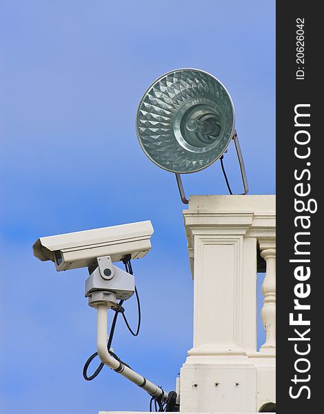 Surveillance camera on building with sun and sky blue background. Surveillance camera on building with sun and sky blue background