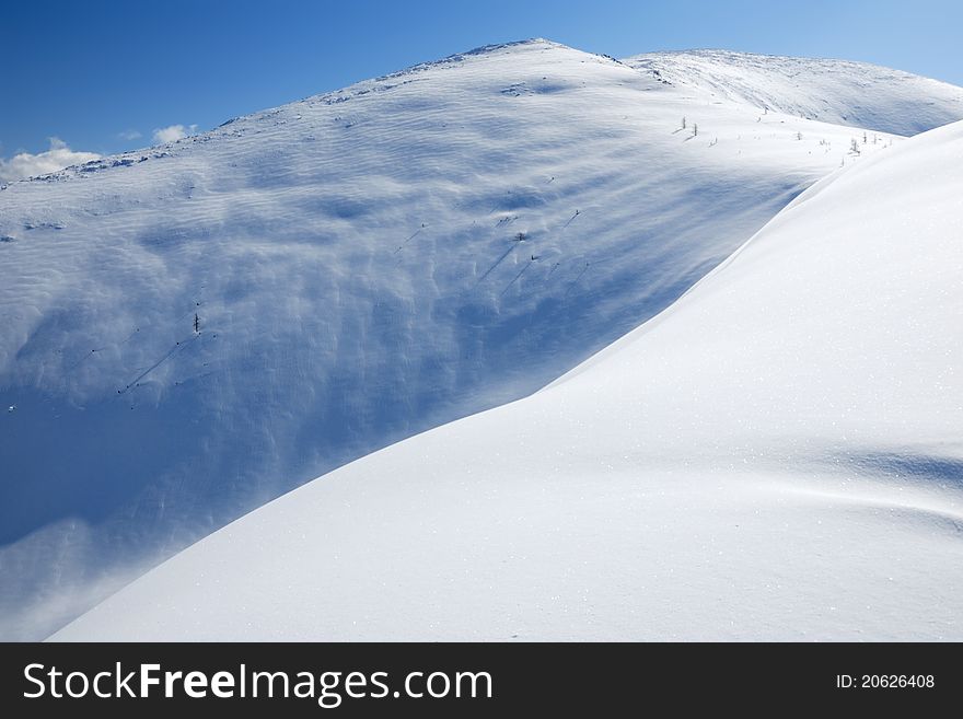 The snow slope in winter mountains. Freeride and backcountry snowboarding/skiing place. The snow slope in winter mountains. Freeride and backcountry snowboarding/skiing place