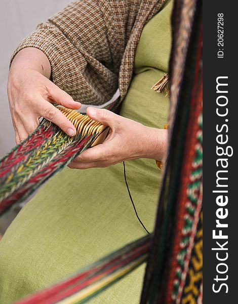 Woman crocheting pattern stripes with traditional tool