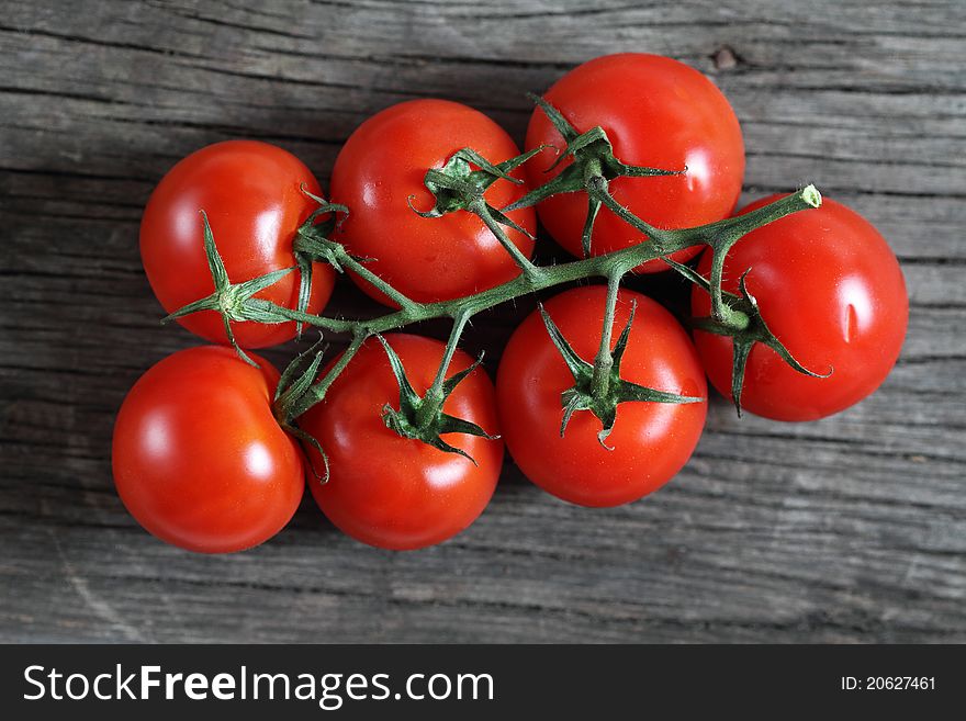 Dewy red tomatoes on the rustic wooden board