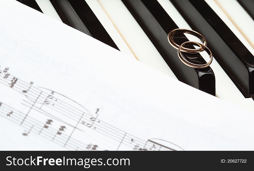 Music of love: wedding rings and score on piano