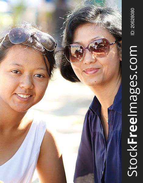 Portrait of happy asian ethnic mature mother and teenage daughter wearing sunglasses. Portrait of happy asian ethnic mature mother and teenage daughter wearing sunglasses