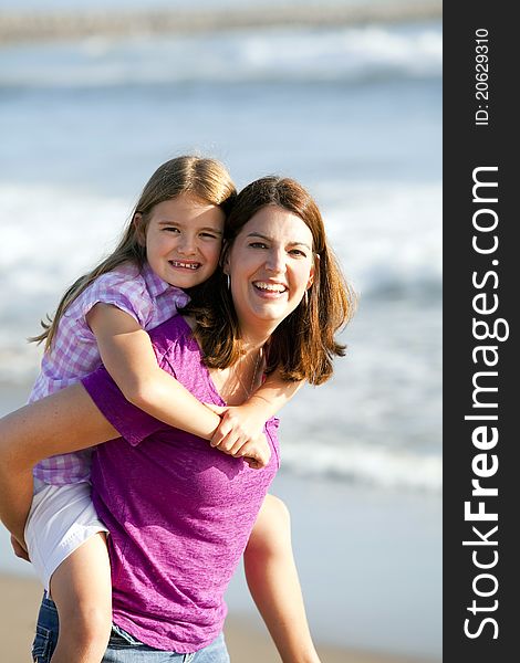 Loving mother and daughter playing on the beach