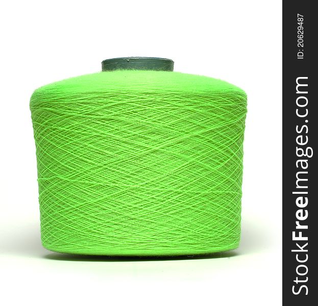 Coil with green thread on white background