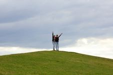 Two Women On Top Of Green Hill Waving Royalty Free Stock Images