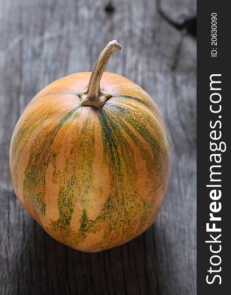 One pumpkin on the rustic wooden background. One pumpkin on the rustic wooden background