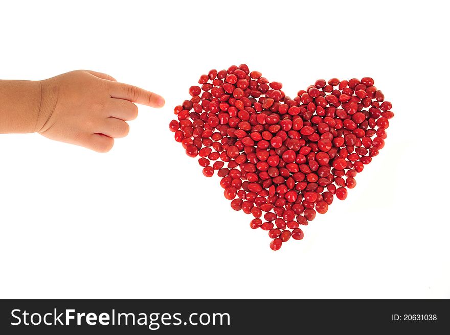 Child Finger Pointing To A Heart Shape Arranged With Red Love  Beans. Child Finger Pointing To A Heart Shape Arranged With Red Love  Beans