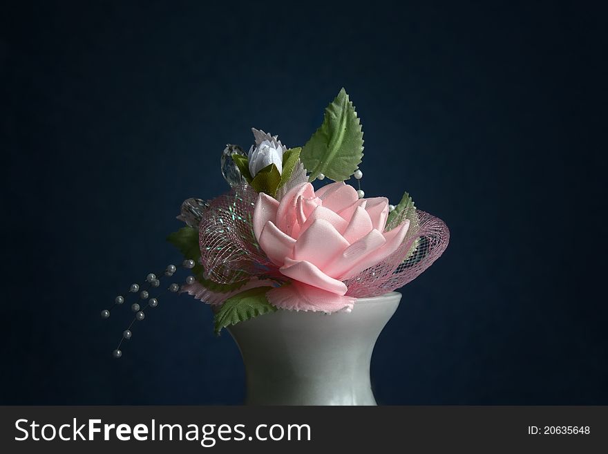 Pink wedding flower in a white vase against a dark background