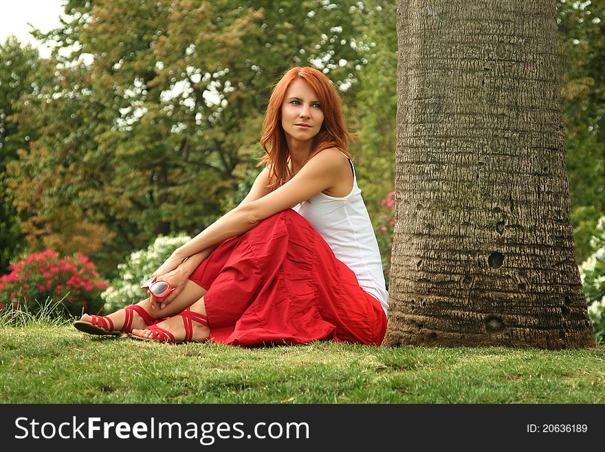 Beautiful young woman relaxing in park. Beautiful young woman relaxing in park