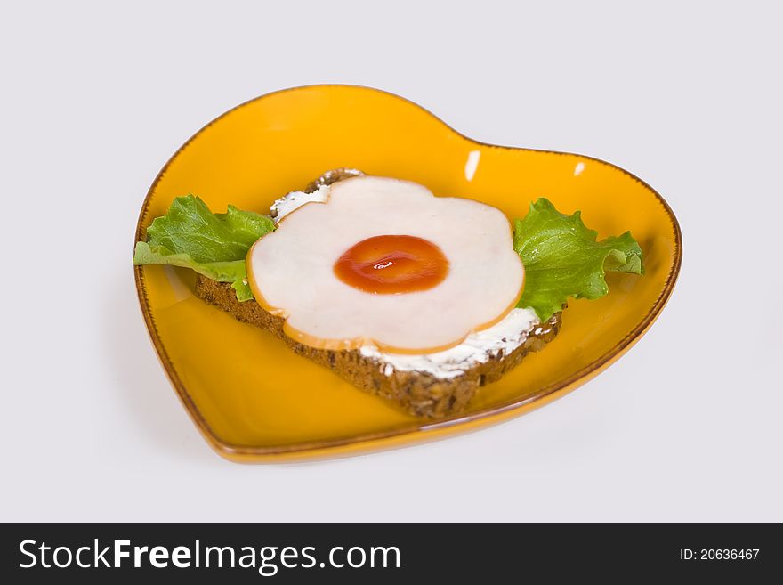 Bread with a slice of ham on a yellow plate