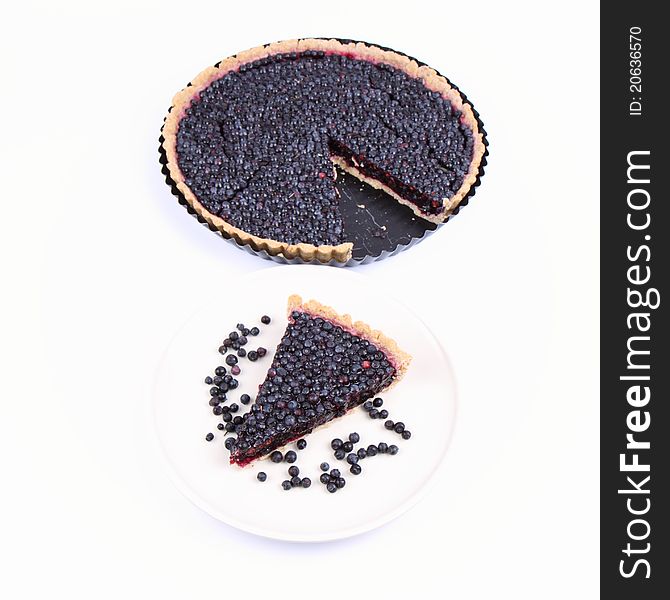 Blueberry Tart: a portion on a plate and in a tart pan on a white background