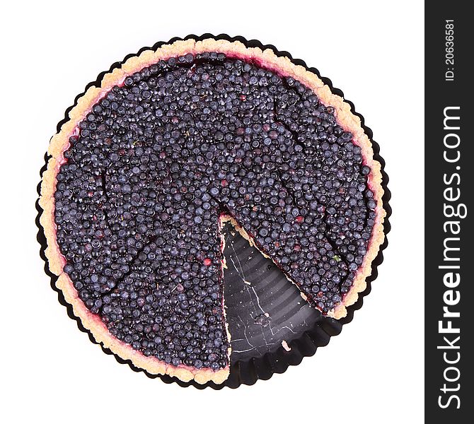 Blueberry Tart in a tart pan with a slice cut out on a white background