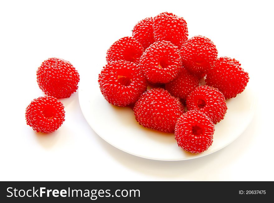Red raspberry on white plate and on white background