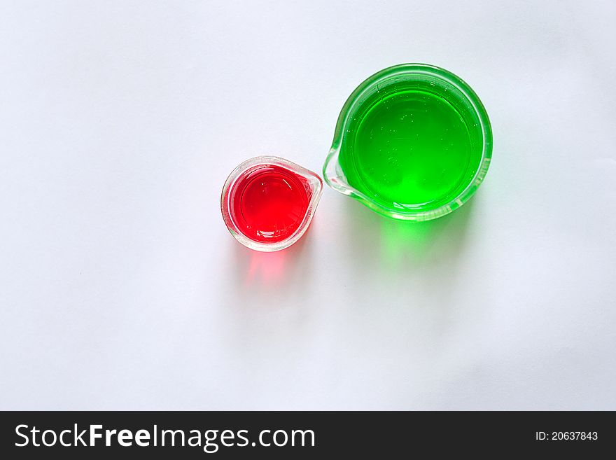 A two beakers contain red and green solution, top view