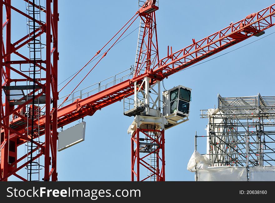 Cranes on a construction site, blue sky in the background