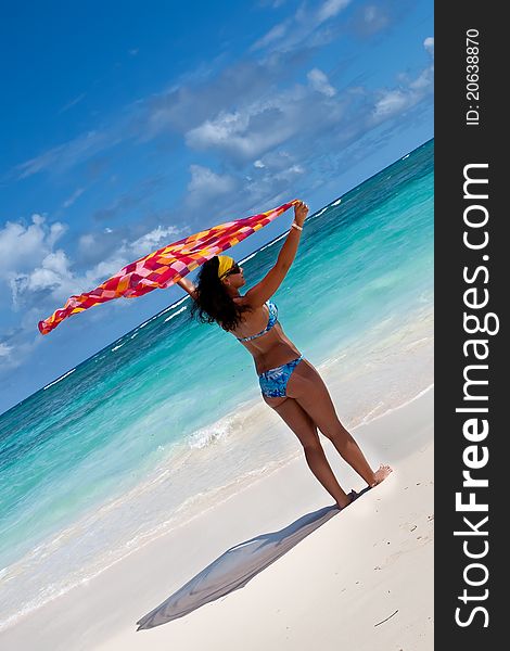 Tanned young europen women with red and orange pareo on white sand beach in summer. Tanned young europen women with red and orange pareo on white sand beach in summer