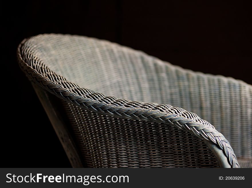 Basket wicker chair in front of black background