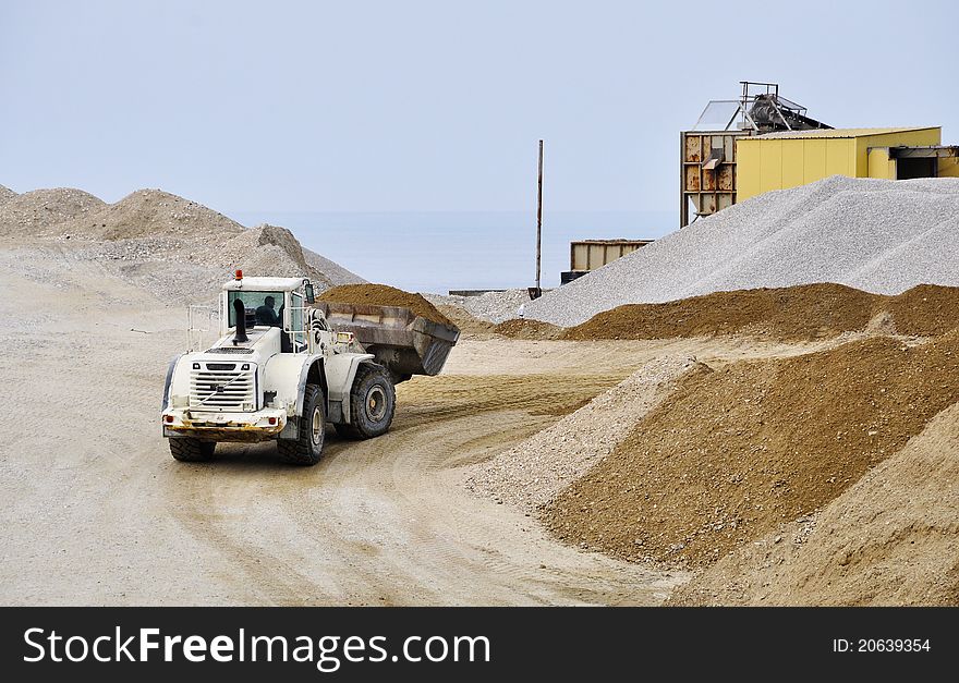 A white bulldozer moving gravel. A white bulldozer moving gravel