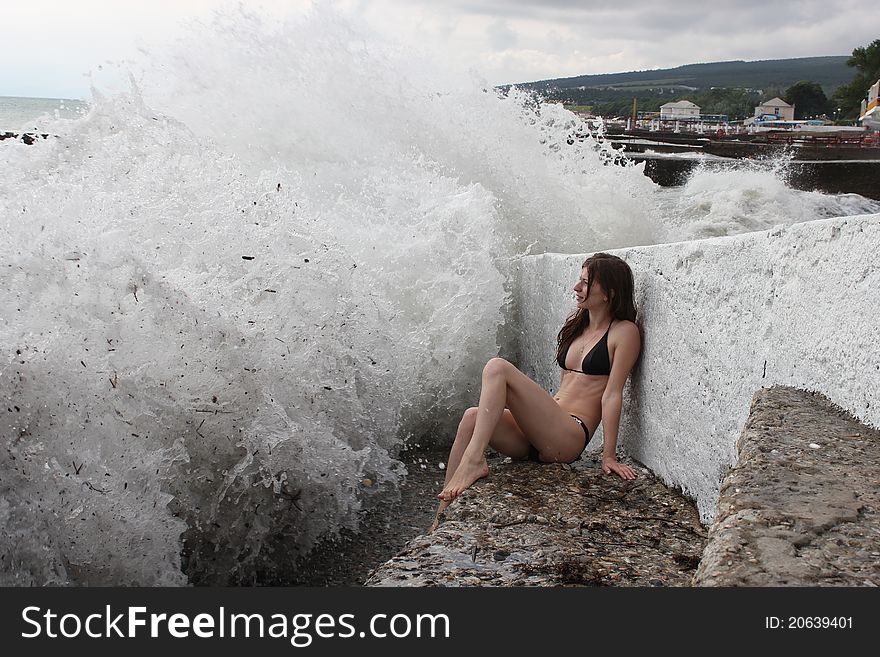 The beautiful and gentle girl against a raging sea storm.