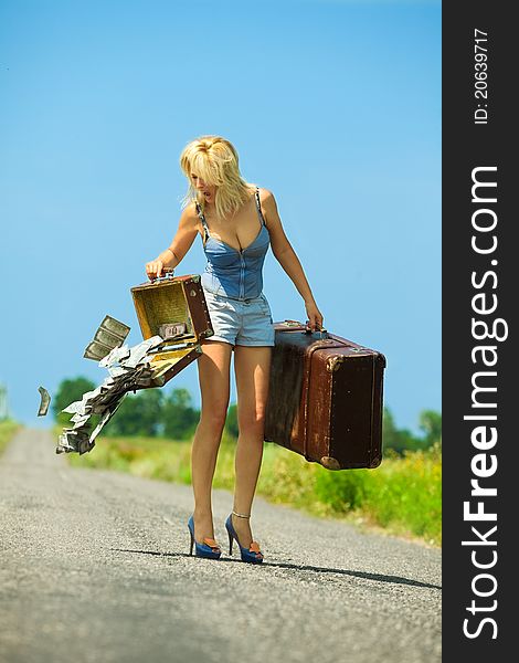 Woman holding  opening suitcases with cash