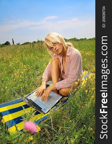 Woman with laptop sitting on blanket