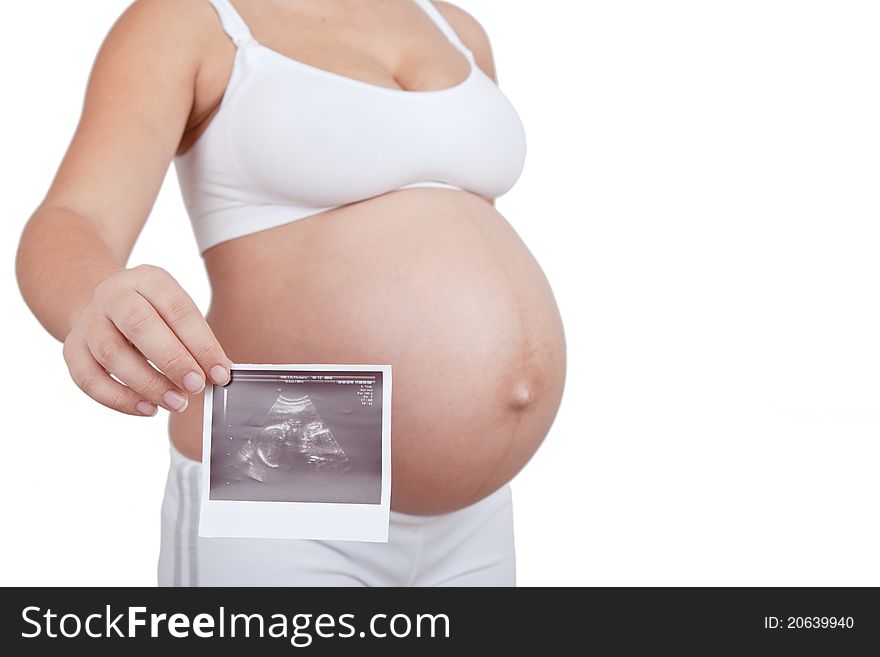 Pregnant woman hold in hand ultrasound investigation picture on a belly