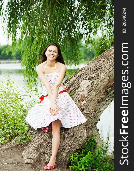 Portrait of a smiling young female model posing in a park - Outdoor