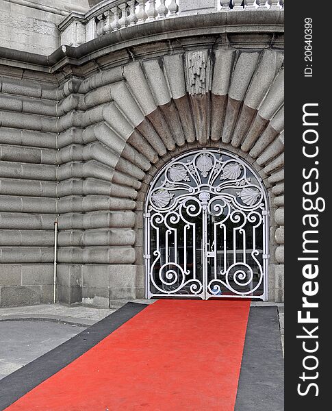 Red carpet leading up to an ornate metal gate