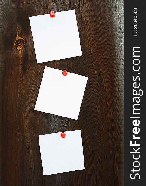 Three white stickers on a wooden background