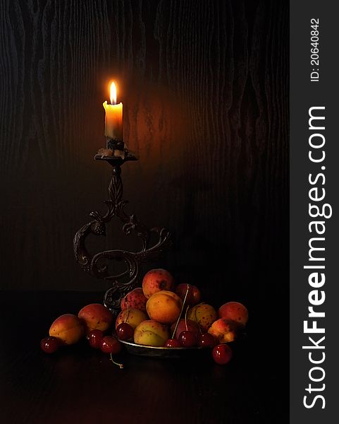Burning candle with berries, apricots and cherries. Burning candle with berries, apricots and cherries