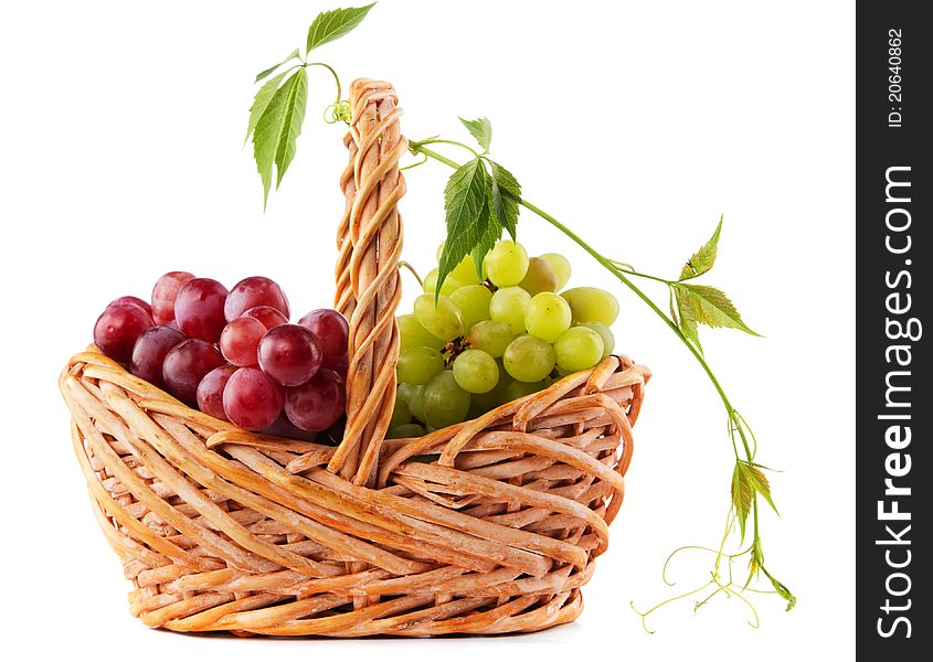 Wicker basket with grapes isolated on white background