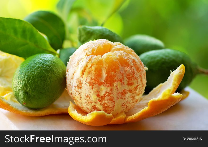 Peeled orange, and green lemons. Peeled orange, and green lemons